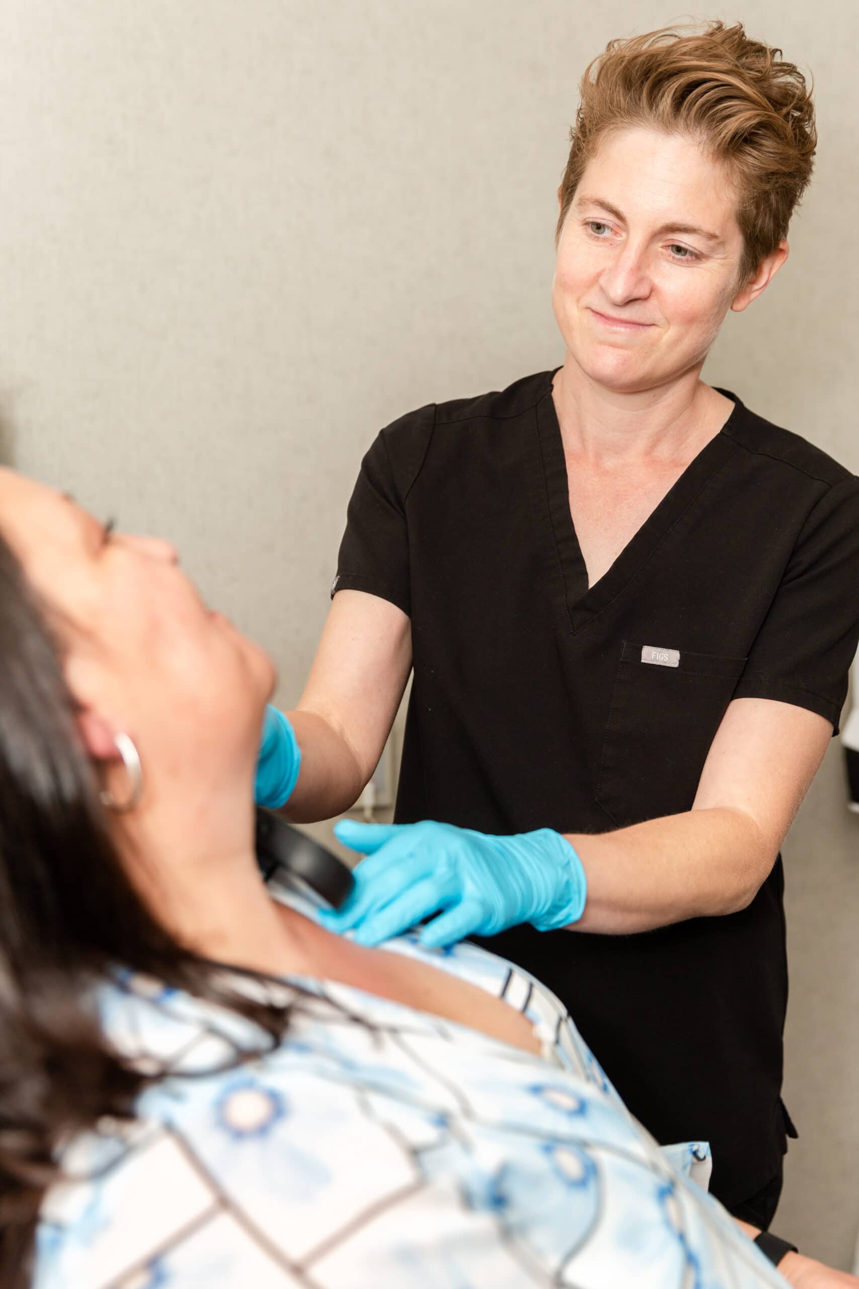 scherl-dermatology-dr-rothman-check-patients-neck doctor with her rosacea patient